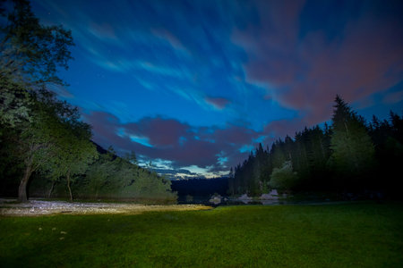 Night time panorama of a mountain lake surrounded by green trees, Lago di Fussine, eastern Italy.の写真素材