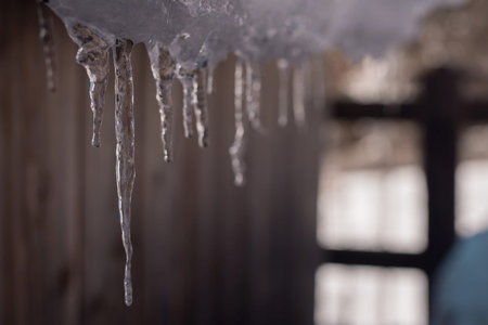 Detail of icicles forming on the lower part of the roof outside.の写真素材