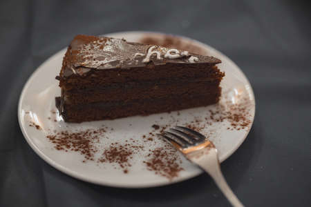 Sacher cake or sachertorte served on a white plate and gray background. Natural looking sacher cake in a restaurant.の写真素材