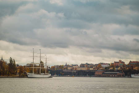 Hostel ship or sailboat of Af Chapman in Stockholm in front of Katarina - Sofia area in the background on a cloudy rainy autumn day.の写真素材