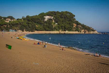 Fenals beach in Lloret de Mar area in Spain. Late clear afternoon setting on a beach with blue ocean...