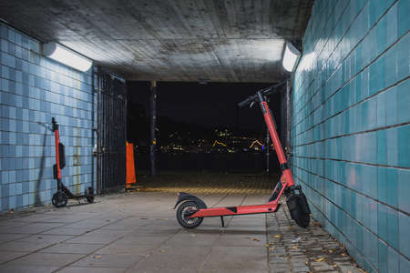 Electric mobility scooter is standing alone in the empty alley of a metro station in Stockholm. Left electric rental scooters for commuting left alone at night.の写真素材
