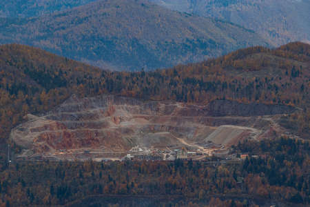 Panorama of a large open quarry or mine looking from a distance. Overview of a quarry of Verd, just above Vrhnika in Slovenia on a cloudy autumn dayの写真素材