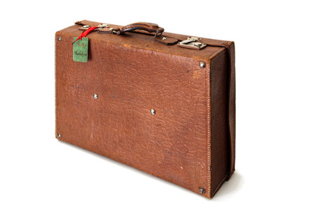 Old retro or vintage suitcase made of brown leather isolated on white background. Happy holidays tag is visible on the suitcase.の写真素材