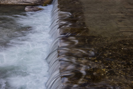 Water flowing down over the man made cascade on the river of San Pellegrino in Val di Fassa in...