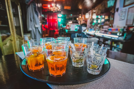 Appetizer drinks and shots waiting on a serving board in a bar waiting for first guests at a pary. Party atmosphere and some drinks in the foregroundの写真素材