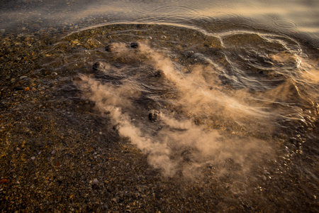 Hot charcoal being thrown in the water. Hot coal in water making a ot of steam and vapor rising from...