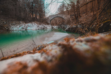 Beautiful stone bridge on Nadige or Nadiza river, called old Napoleon bridge. Enchanted magical stone bridge in cold late autumn environment. View over leavesの写真素材