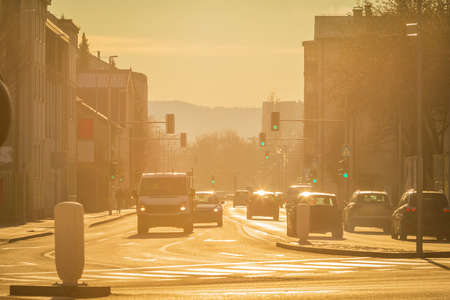 Early morning view of rush hour traffic on a wide street in a city. Strong backlight.の写真素材