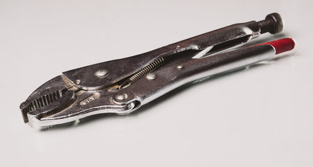 Grip pliers on a white reflective background.