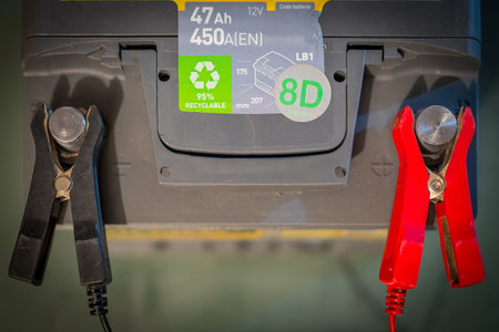 Black and red battery clamps on terminal of a car battery while charging. Concept of refreshing or...