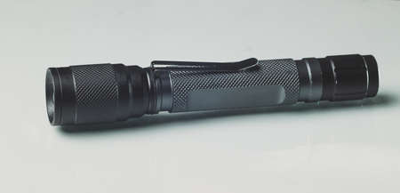 LED torch made of black anodised metal or aluminium. Modern LED hand torch on a white background.の写真素材