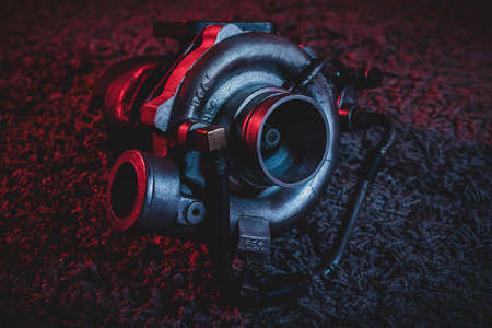 An old reconditioned car turbine, turbocharger, with red and blue lighting.の写真素材