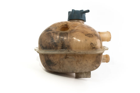 Old and worn rounded car coolant expansion tank on a white background, isolated on white. Worn automotive parts in dirty condition. Side viewの写真素材