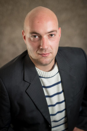 Portrait of modern business hipster crypto man in a striped sweater and a black dress or jacket on a...
