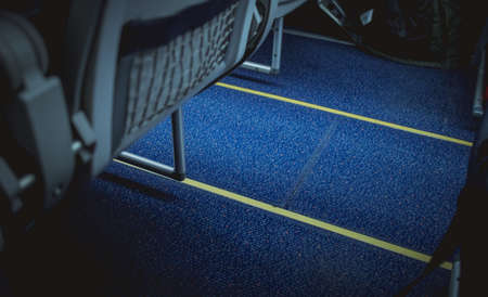 Escape lines or path in the aeroplane aisle on the floor. Visible lines on the floor carpet between the chairs.の写真素材