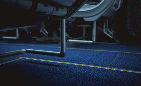 Escape lines or path in the aeroplane aisle on the floor. Visible lines on the floor carpet between the chairs.の写真素材