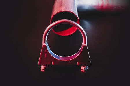 Metal exhaust clamp with a pipe in the background. Dramatical modern blue and red lighting.の写真素材