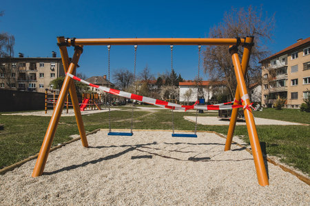 Closed children playground or swing on a chain due to corona virus restrictions taking in effect....