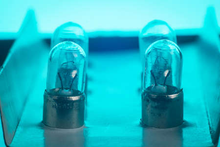Detail of older type position lamp bulb of a car. Multitude of position lightbulbs in a bulk cardboard packaging.の写真素材