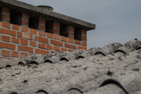 Old roofing tiles made of asbestos and cement. Dangerous and unhealthy roofing, visible old red...