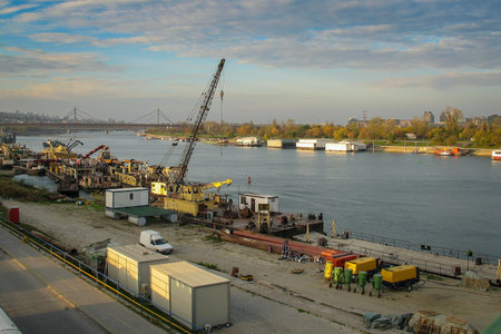 Cranes, containers and other machinery on the banks of Sava river in the docklands of Belgrade in...