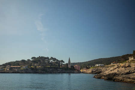 View of the village of Veli Losinj in the Croatian island. Looking towards the port or marina of the village. Beautiful colorful houses and church are seen.の写真素材