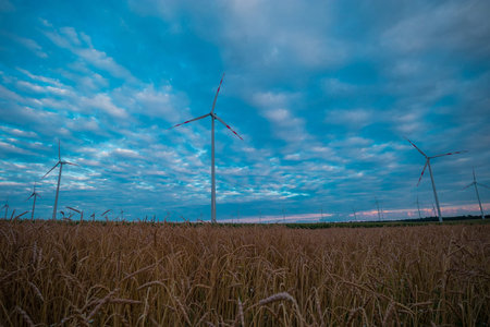 Electric power generator wind turbines on a vast field in Austria close to Vienna on a colorful...