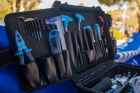 An assortment of modern blue coloured bicycle tools in a tool box or pouch on a work bench.の写真素材