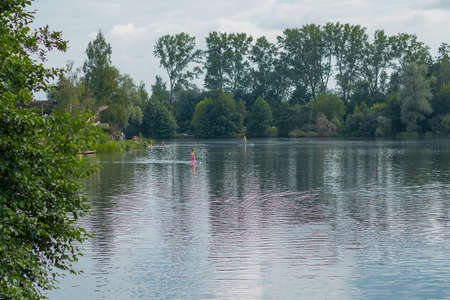 Unknown sup paddlers on podebrady lake in czech republic at the town of Olomouc. Water activitiews in Olomouc.の写真素材