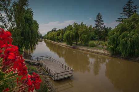 Emty pier on a dirty brown river Begej in Timisoara, Romania. visible on a sunny summer day with...