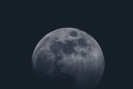 Full moon over dark background sky. Closeup of a moon on the sky, with slight fade to black on the bottom. Round shape of a moon on black sky.の写真素材
