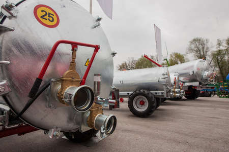 Scene from a farm business fair, showing a collection of manure tankers in stainless steel color. Detail of hose couplings on a tanker.の写真素材