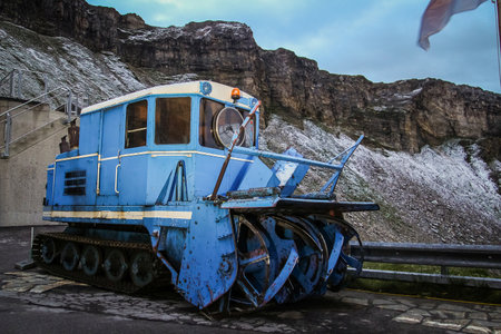A blue snow blower with tracks used to clean high alpine road on Grossglockner, Austria. Old reliable machine to clean snow from the road surface.の写真素材
