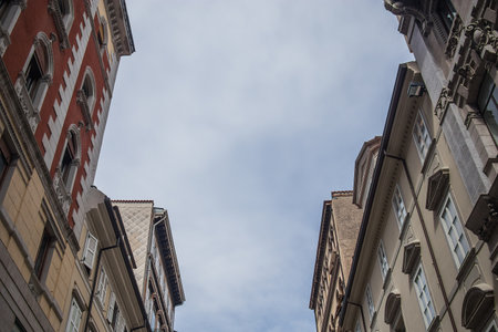 Front faces or facades of typical houses in northern italy, in the port town of Trieste on a sunny but still cloudy day.の写真素材