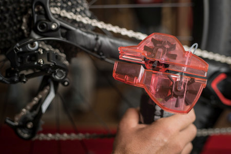Cleaning of bicycle chain using a dedicated tool for cleaning. Plastic container with rotating brushes for cleaning the chain.の写真素材