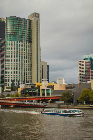 Central business district in Melbourne, Australia, with small boat floating on Yarra river.の写真素材