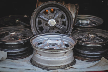 A collection of old steel wheels stacked around in a trunk of a car.の写真素材