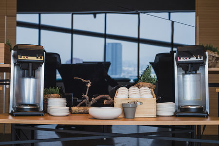 Frontal view of two coffee machines on a desk used for coffee break on an event or a meeting. Coffee time on a seminar - table with machines ready to serve coffee.の写真素材