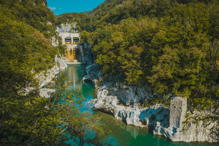 Small water dam of Podselo in river Soca close to Most na Soci, water dam surrounded by lush green and white chalk rock on a summer day.の写真素材