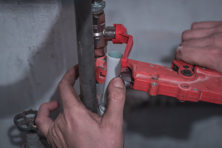 Manual hand pliers or cutter used on a plastic or polypropylene pipe for heating. Professional plumber  on house renovation.の写真素材