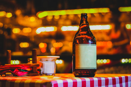 Brown bottle of beer on a bright colorful background at a club or restaurant at night. Ambient style product photo of a beer bottle with white sticker.の写真素材