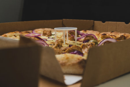 Pizza saver or ottoman, known also as pizza table, used in pizza deliveries to save the pizza being squished in a cardboard box. Tasty delicious pizza being saved by pizza saver.の写真素材