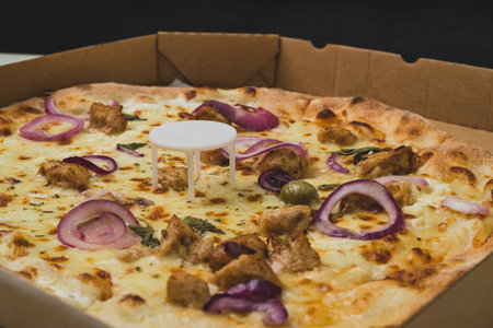 Pizza saver or ottoman, known also as pizza table, used in pizza deliveries to save the pizza being squished in a cardboard box. Tasty delicious pizza being saved by pizza saver.の写真素材
