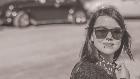 Black and white portrait of a sexy young dark haired hipster girl with sunglasses and piercing in...