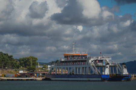 Ferry transporting people and cars through the Dardanele strait between the towns of Eceabat and Canakkale, Turkey, on a cloudy day.の写真素材