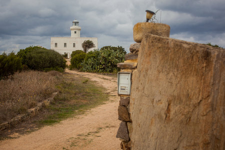 Lighthouse on Capo Ferro on the north of Sardinia, Italy. White house with lighthouse  surrounded by lush mediterranean greens.の写真素材