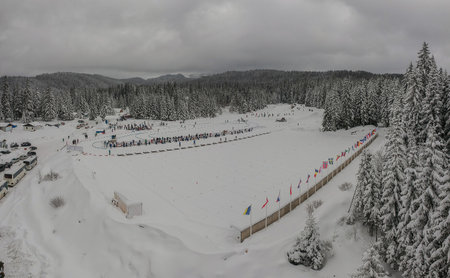 Aerial drone panorama of a biathlon stadium  or shooting venue, with visible national flags and snowy forests in the background close to Sarajevo on the plain of Dvorista.の写真素材