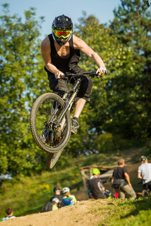 Frontal shot of a mountainbiker jumping over a dirt jump in a bike park.の写真素材
