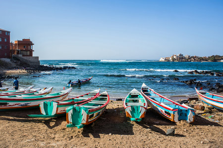 Fishing boats in Ngor Dakar, Senegal, called pirogue or piragua or piraga. Colorful boats used by fishermen standing in the bay of Ngor on a sunny day.の写真素材